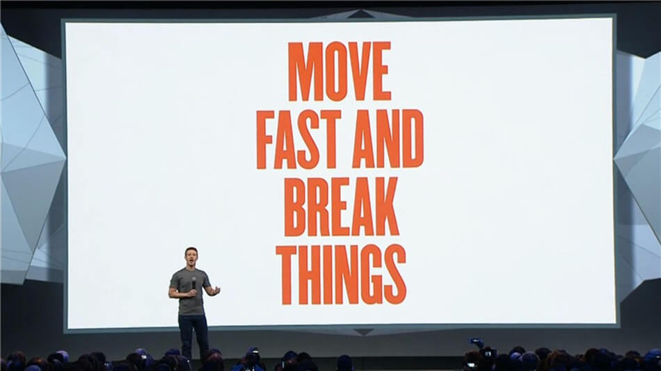 Alida Miranda-Wolff, To Grow Talent, Don’t Move Fast and Break Things — Move Slow and Build Them article, feature image, man at conference with a background that says "Move Fast and Break Things"